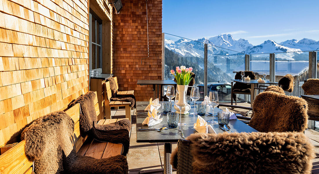 Sun terrace of Hotel Sonnasita in winter, cozy furnished with sheepskin throws.