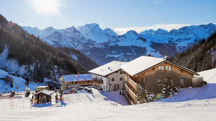 Snowy exterior view of the Hotel Sonnasita in a wintry mountain landscape.