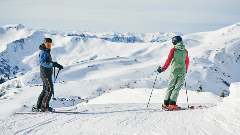 Zwei Skifahrer genießen die Aussicht auf die Berglandschaft in Damüls/Faschina.